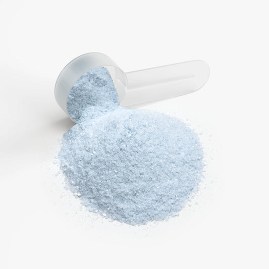 Light blue powder in a white scoop on a white background